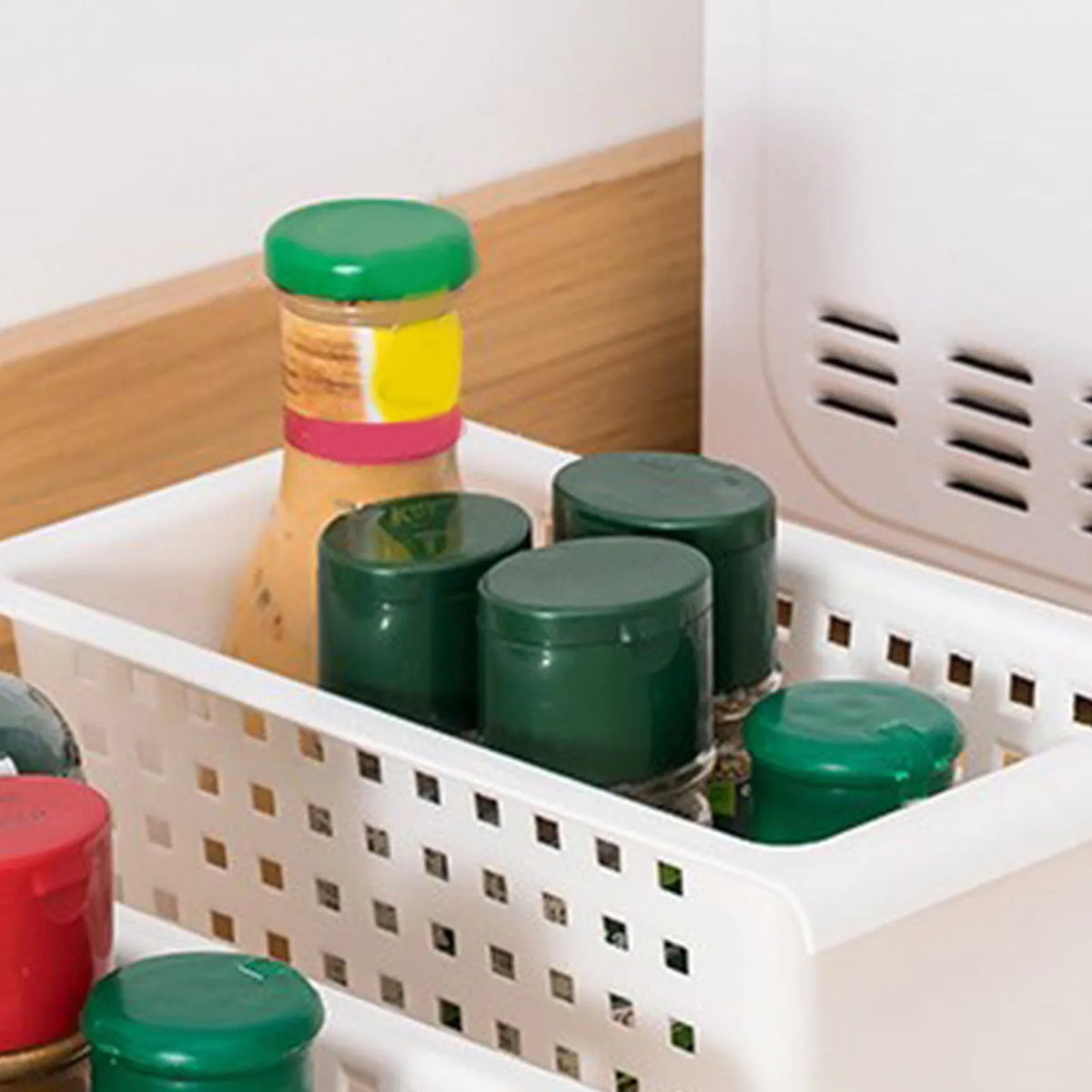White hanging storage basket filled with assorted jars and bottles