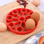 Red silicone 9-hole egg steamer rack with circular compartments and center stem