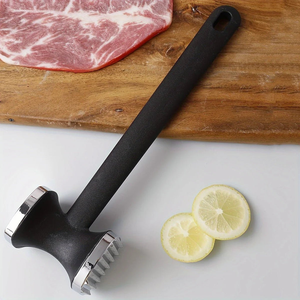 Meat tenderizer mallet on a wooden board with steak and lemon slices