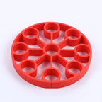 Red silicone 9-hole egg steamer rack, evenly spaced circular wells