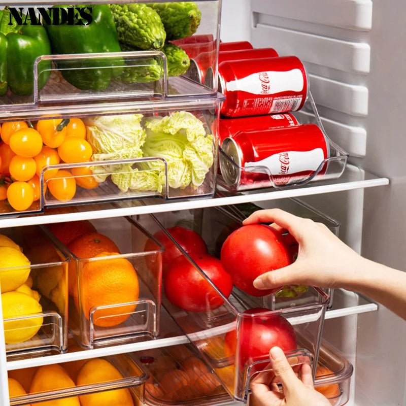 Clear stackable refrigerator storage bin with built-in handles, filled with vegetables
