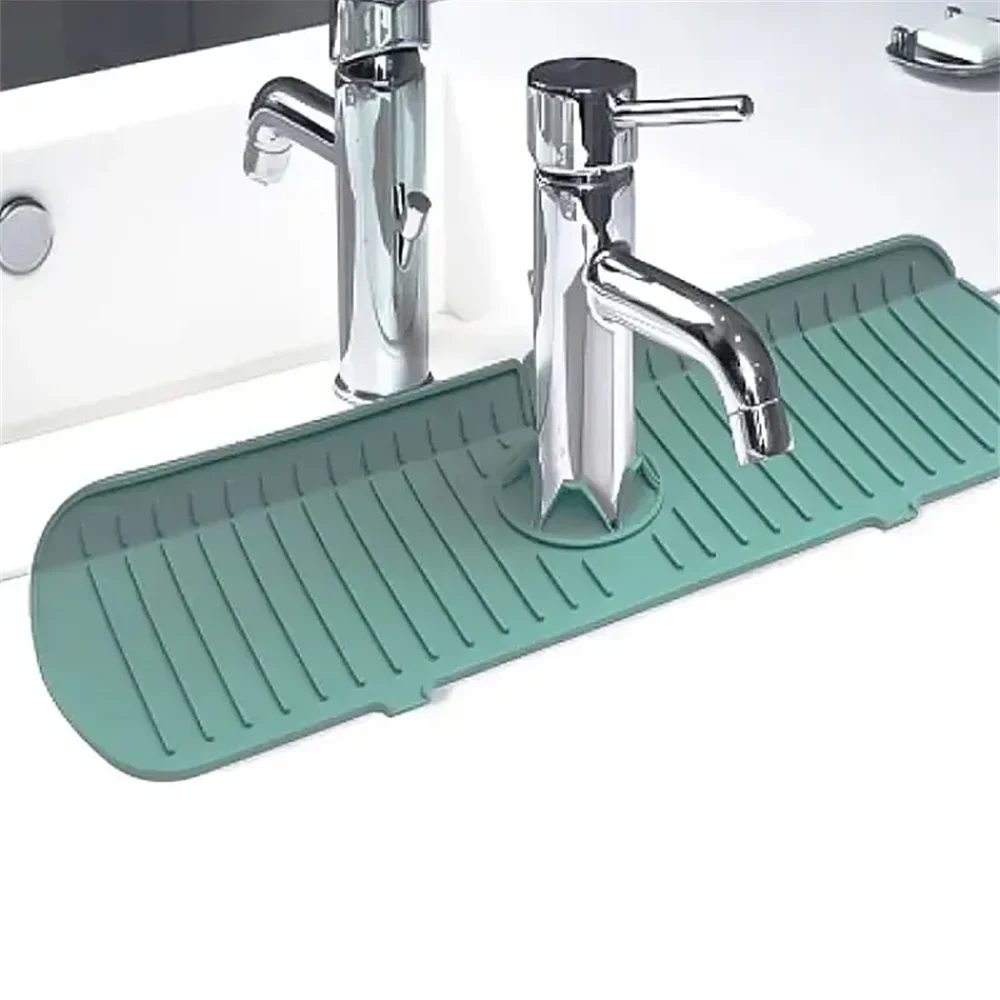 Green silicone faucet splash guard with drain mat ridges beneath chrome faucets