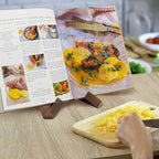 Wooden cookbook stand with interlocking cross base holding an open recipe book