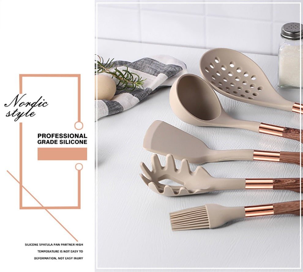 Beige silicone cooking utensil set with rose-gold handles on countertop display