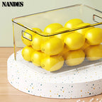 Clear bin with built-in handles for holding yellow lemons on a round turntable