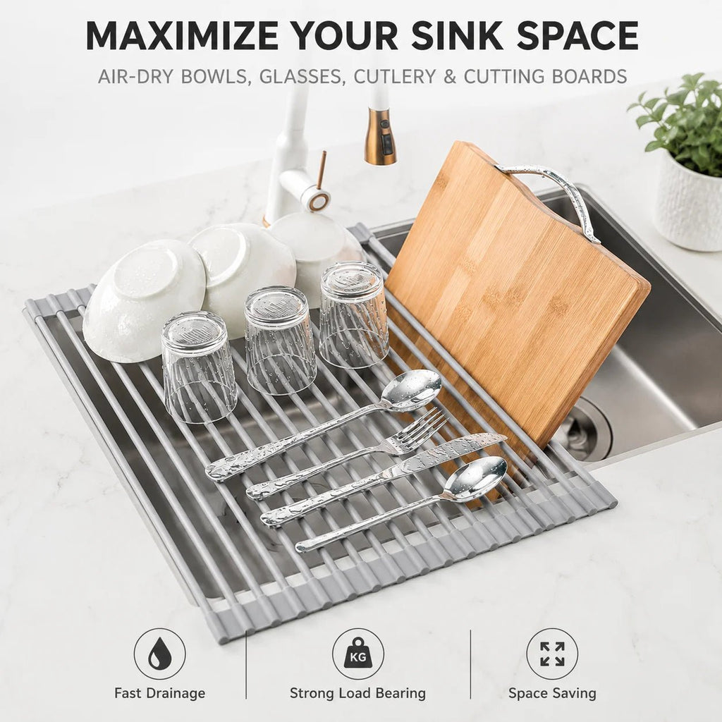 Roll-up dish drying rack with gray silicone-coated slats in sink, holding bowls and cutlery
