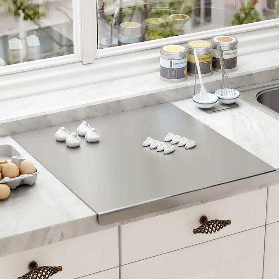 Stainless steel pastry and cutting board on countertop with smooth flat surface