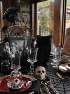 Black spider-web lace table runner covering a dining table with glassware