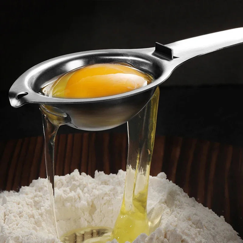 Stainless steel egg separator pouring separated whites from metal yolk cup
