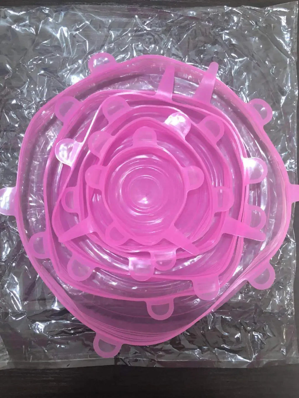 Reusable silicone stretch lids set in pink, stackable circular lids with pull tabs