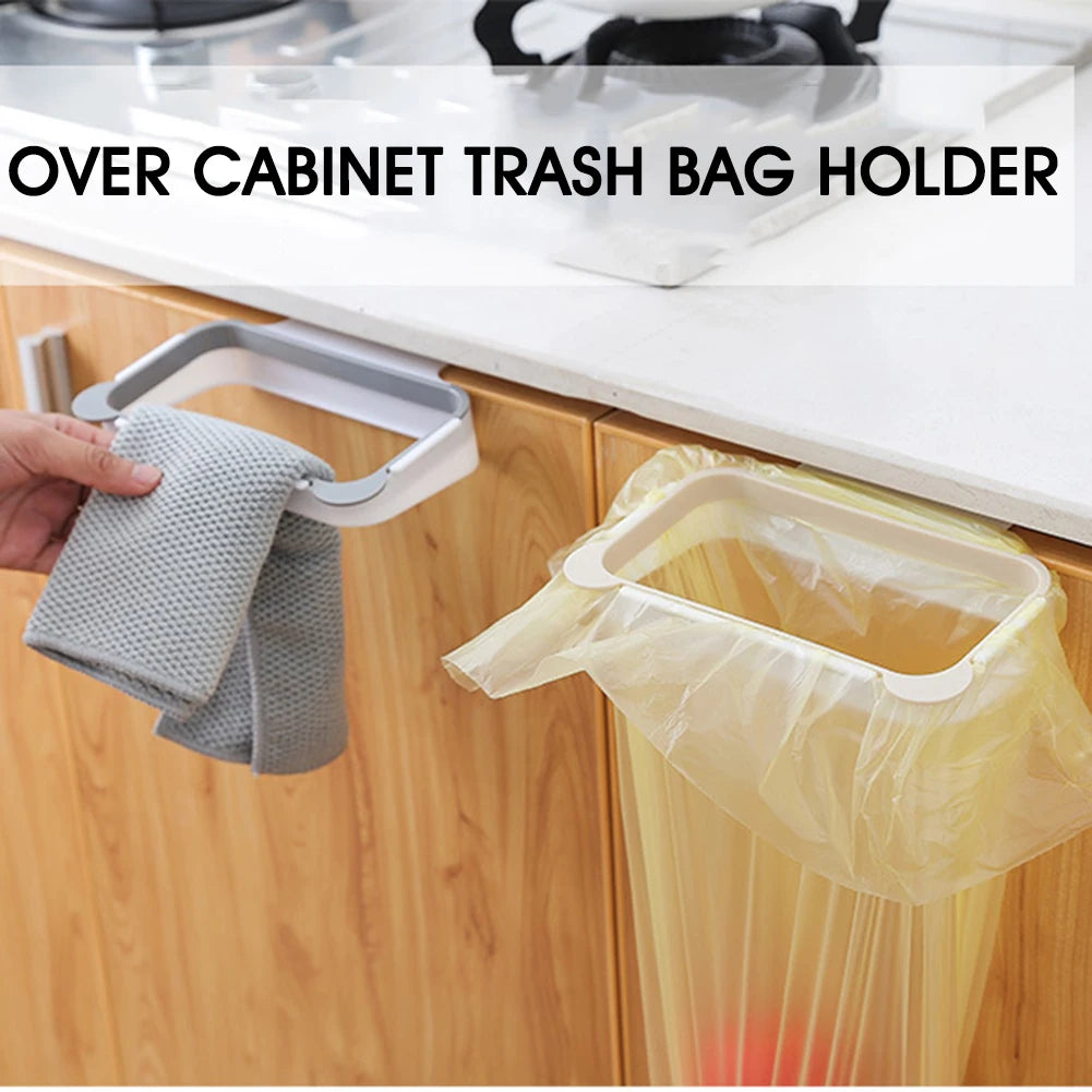 Grey over-cabinet trash bag holder with a grey cloth and translucent bag clipped on