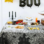 Black spider web lace table runner on dining table with scalloped border
