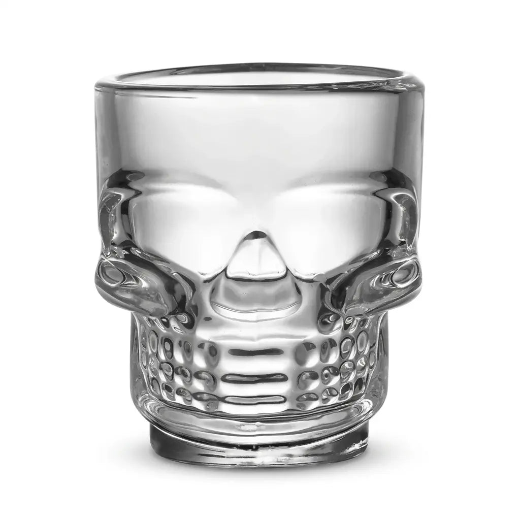 Clear glass skull-shaped Halloween drinking cup on white background.