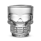 Clear glass skull-shaped Halloween drinking cup on white background.