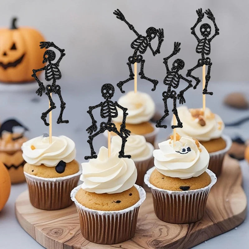 Black skeleton cupcake toppers on cupcakes with white frosting and wooden sticks