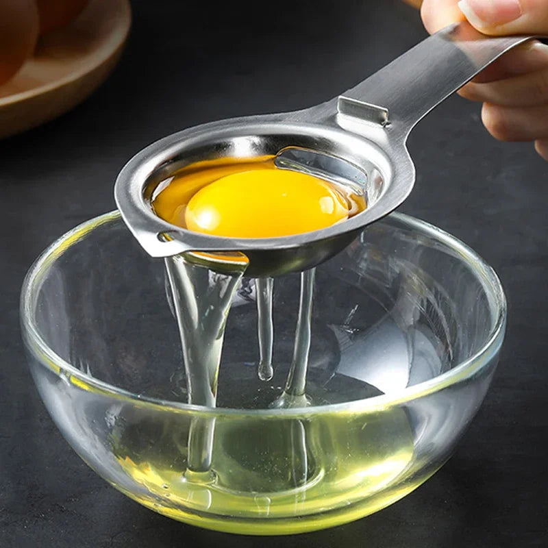 Stainless steel egg separator over bowl, yolk in cup held above bowl