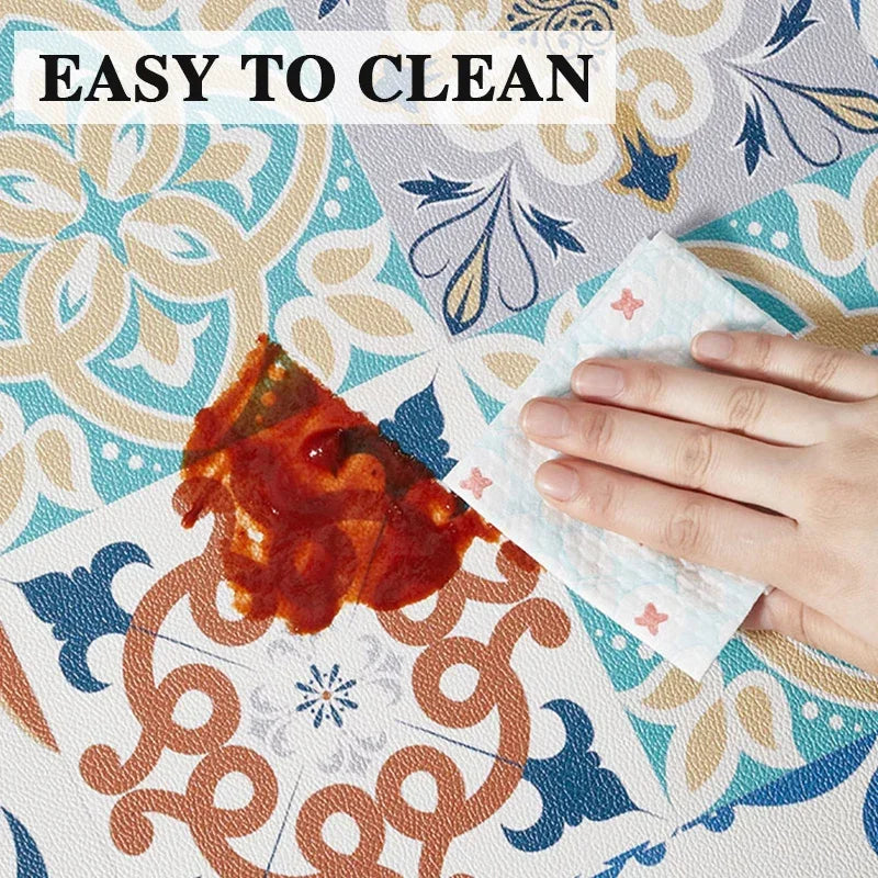 PVC kitchen floor mat surface with blue and white floral tile pattern; wipe cleaning shown.