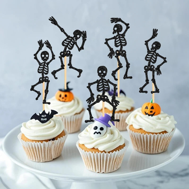 Black skeleton cupcake toppers on sticks with frosted cupcakes on a serving plate