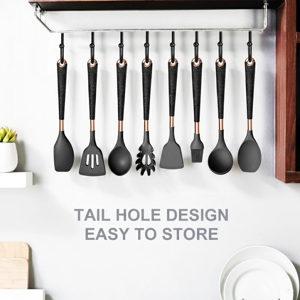 Black silicone cooking utensils with rose-gold tips on hanging storage rail