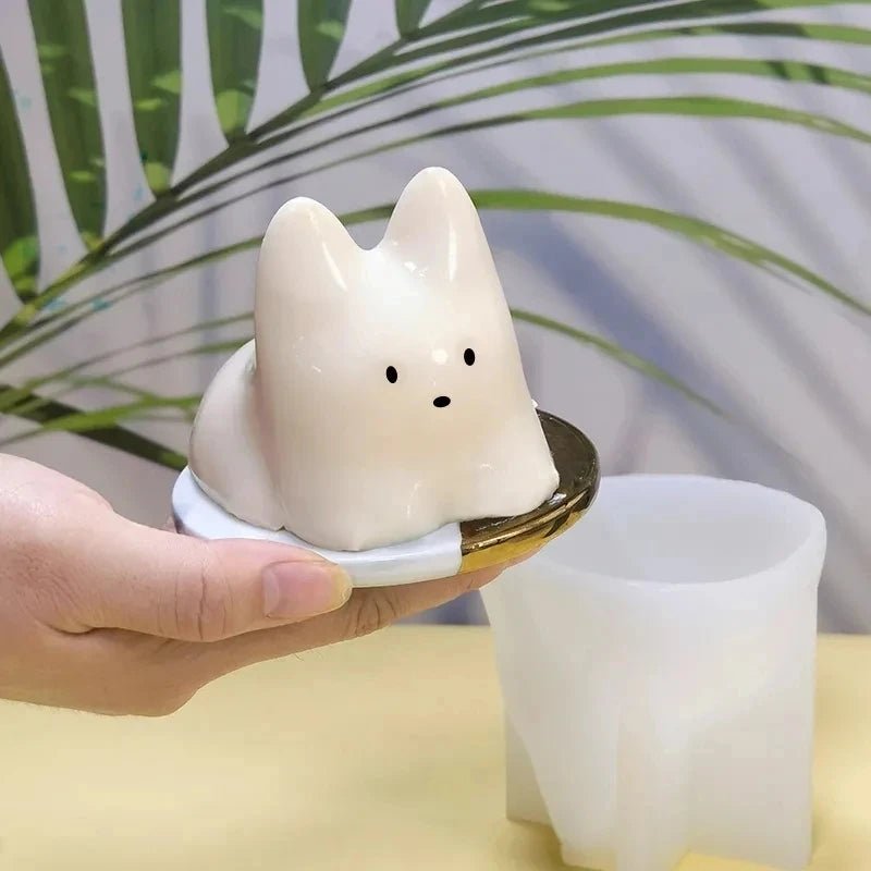 White cat-shaped pudding mold in use, hand holding cat insert over tray