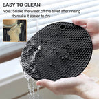 Black silicone round trivet mat with honeycomb texture, rinsed under running water