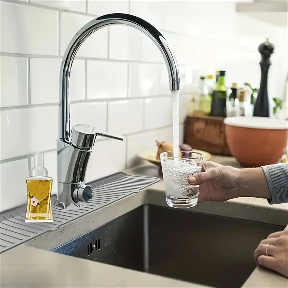 Gray silicone drain mat under faucet with water channels and cup on countertop