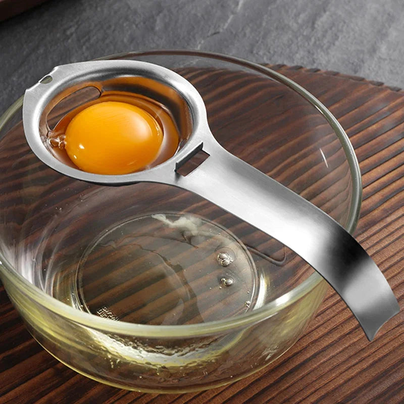Stainless steel egg yolk separator with bowl rest hook, holding one egg yolk in bowl