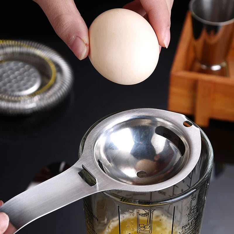 Stainless steel egg separator with long handle, yolk cup over bowl