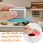 Stainless steel snack cup with teal silicone lid being pressed on