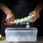 Ice cube tray with clear lid; mint green silicone cubes; hands lifting the lid