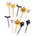 Halloween food picks with spider, bat, jack-o-lantern pumpkin, ghost, and skull shapes in orange, black, and white on white background.