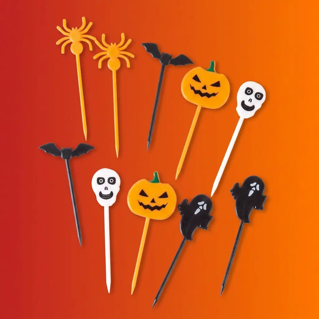 Halloween food picks with spider, bat, jack-o-lantern pumpkin, ghost, and skull shapes in orange, black, and white on orange-red gradient background.