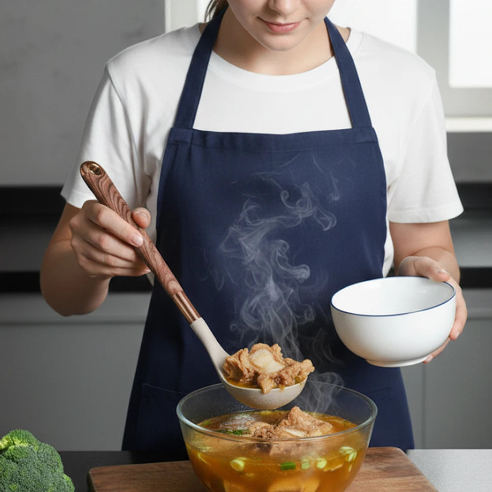 Cook holding a beige silicone spatula with rose-gold handle over a pot of food