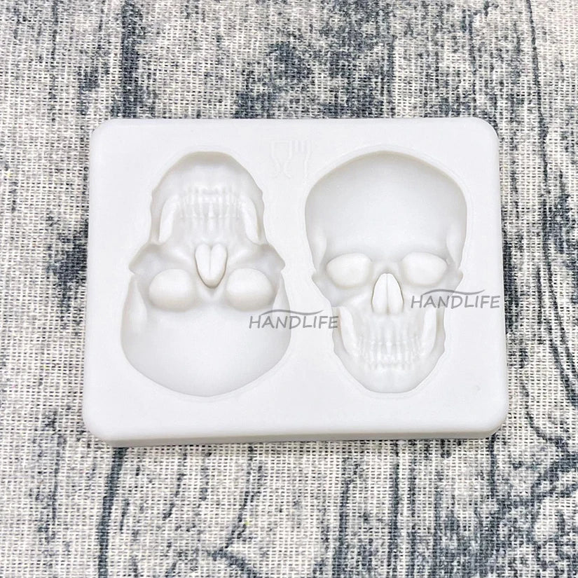 Skull silicone cake mold tray with two skull cavities; white skull cakes set inside