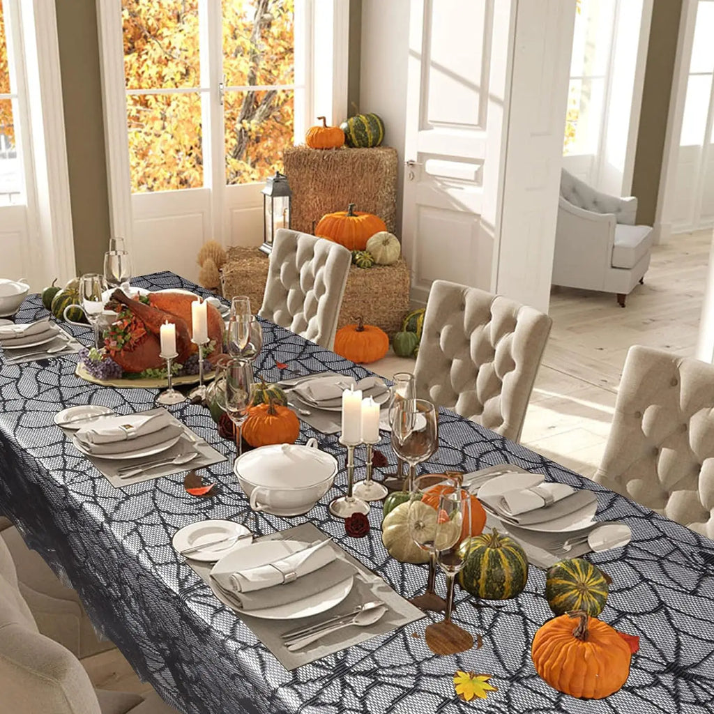 Black spider-web lace table runner spread on table with Halloween decorations