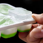 Mint green ice cube tray close-up with silicone release and clear lid